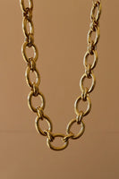 Gold chain necklace on a brown background