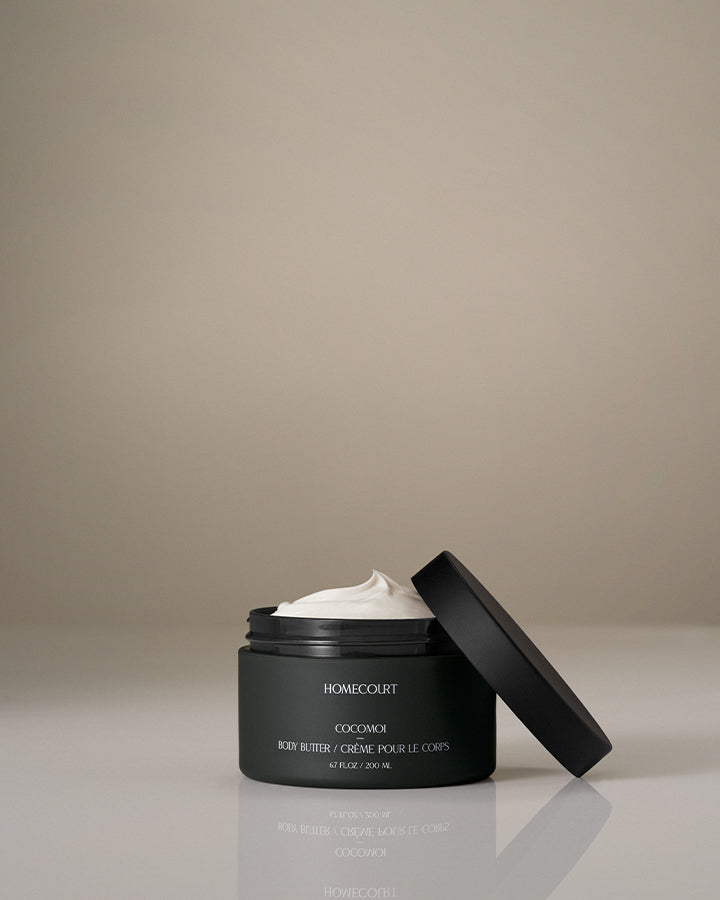 Black jar of Homecourt body butter with a beige background