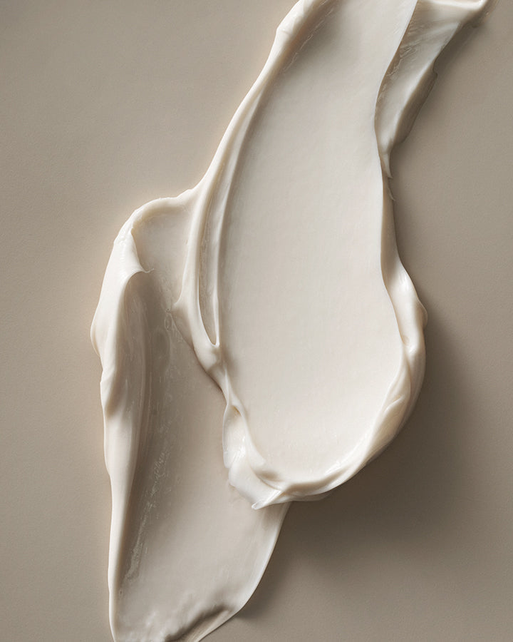 Close-up of smooth, white cream on a beige background