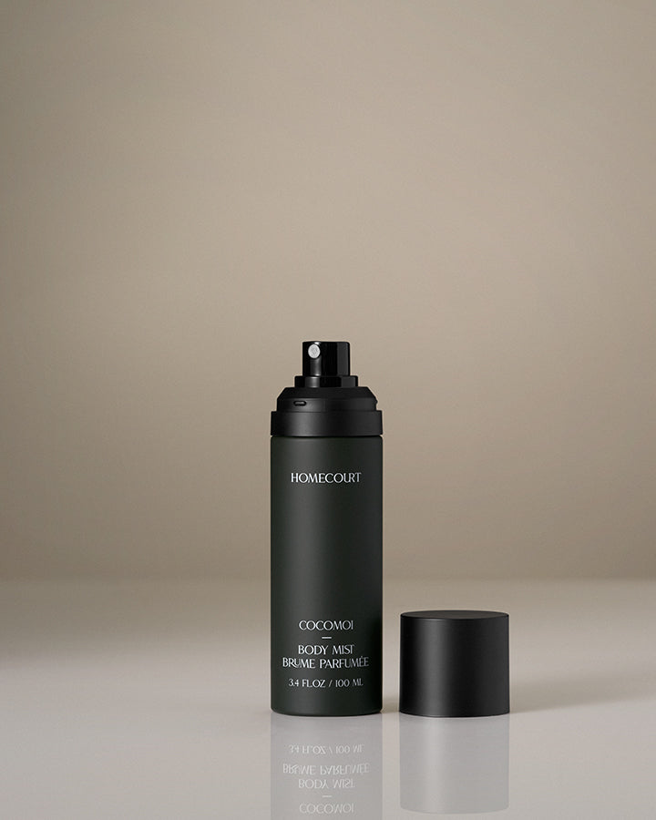 Black perfume bottle with cap on a beige background