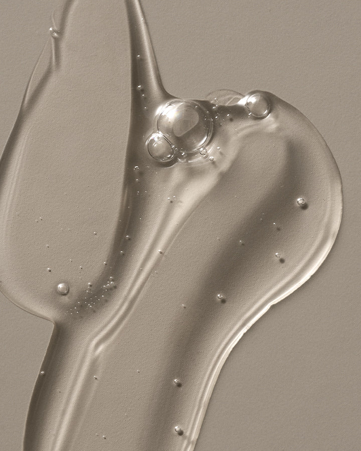 Close-up of a smooth, grayish surface with a wavy pattern of cleanser