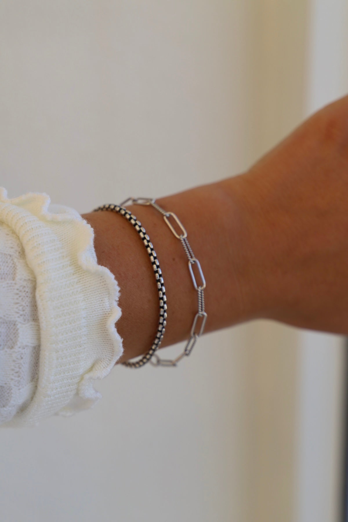 Close-up of a wrist wearing two bracelets on a blurred background