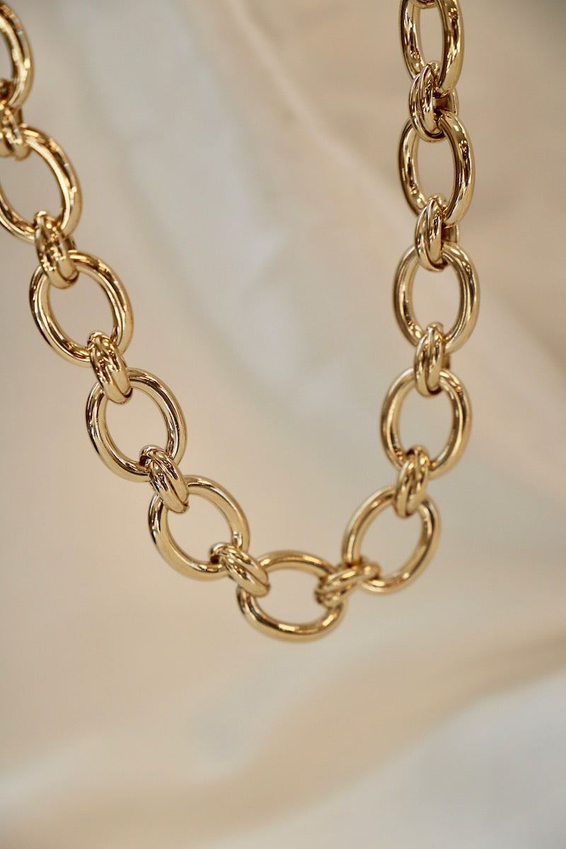 Gold chain necklace on a soft beige background