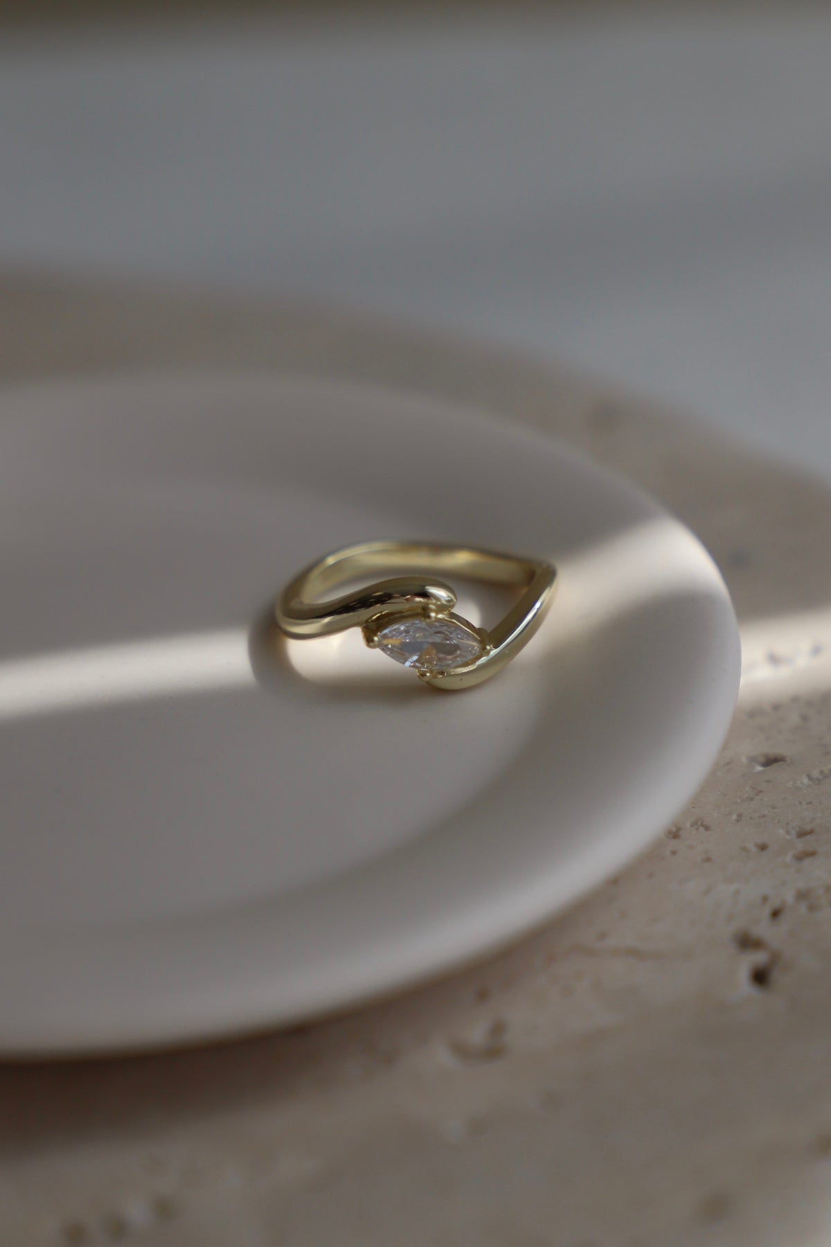 Gold ring with a diamond on a white plate
