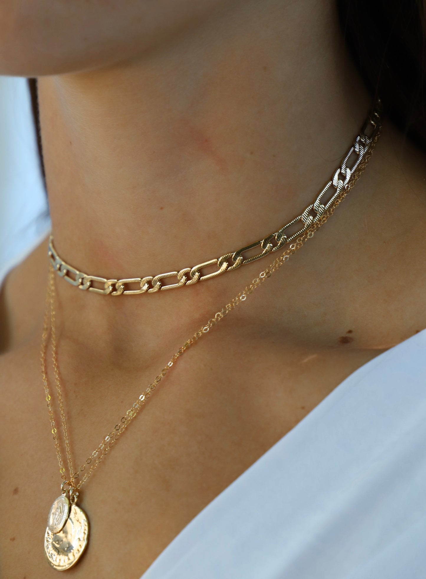 Gold chain necklace on a person with a blurred background