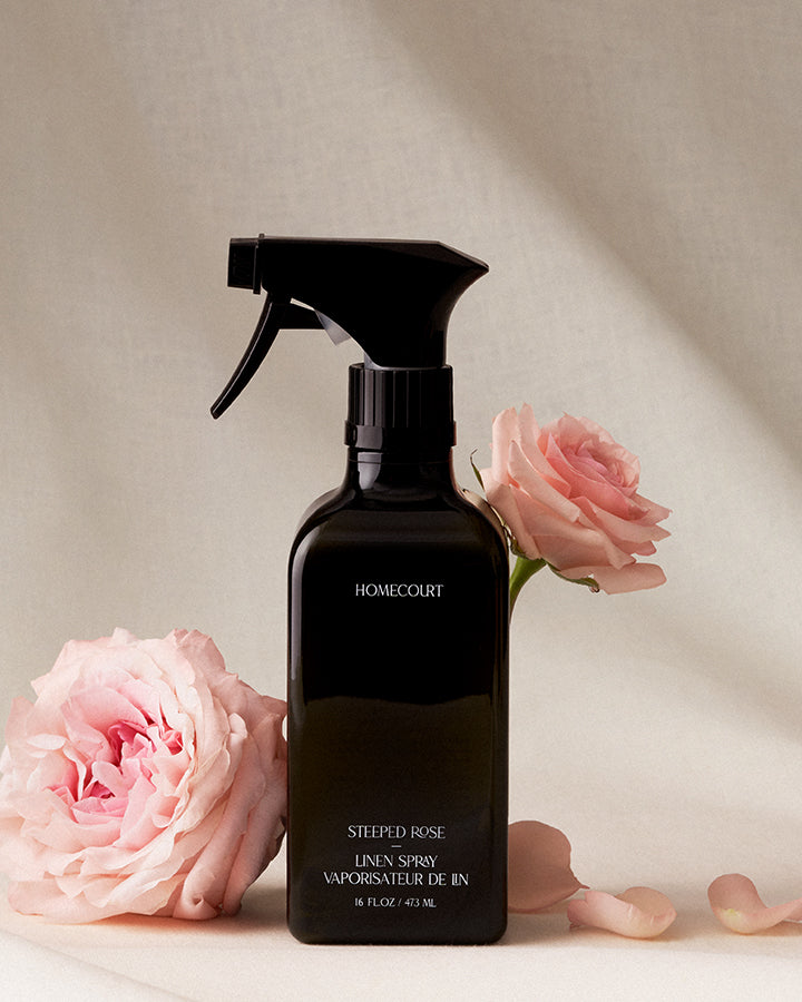 Black linen spray bottle with pink roses on a light background
