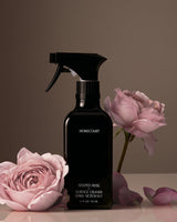 Black spray bottle labeled 'Homecourt' with pink roses on a brown background