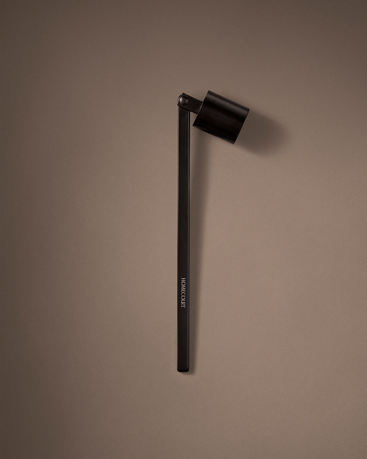 Black candle snuffer on a brown background