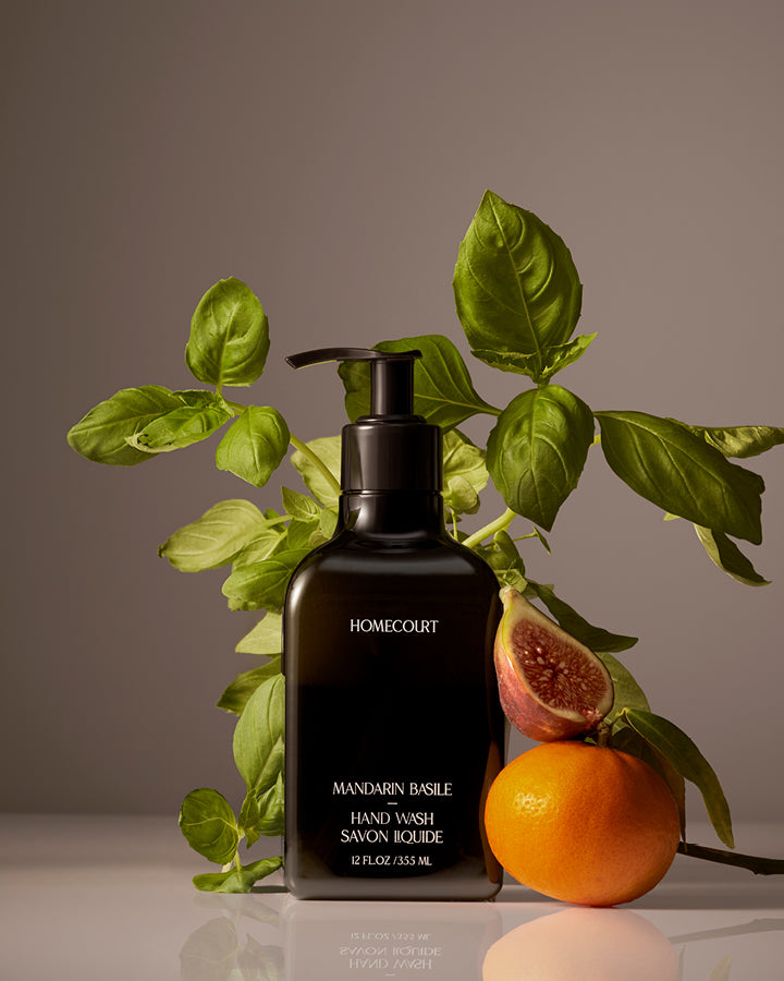 Homecourt Mandarin Basil hand wash bottle with fig and orange on a neutral background