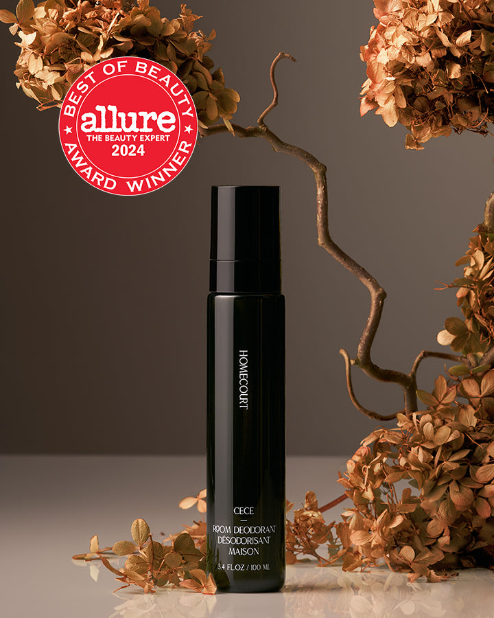 Black bottle with decorative elements and Allure Best of Beauty award badge on a neutral background