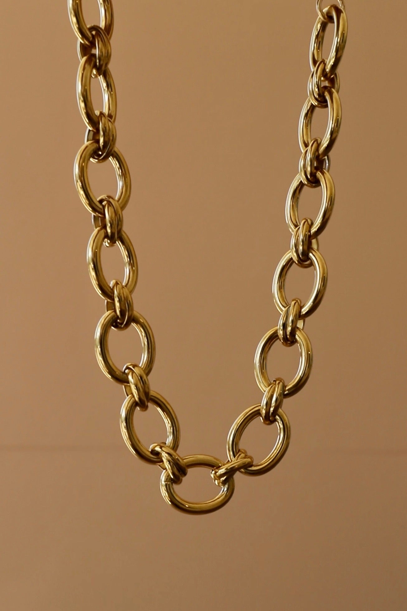 Gold chain necklace on a brown background