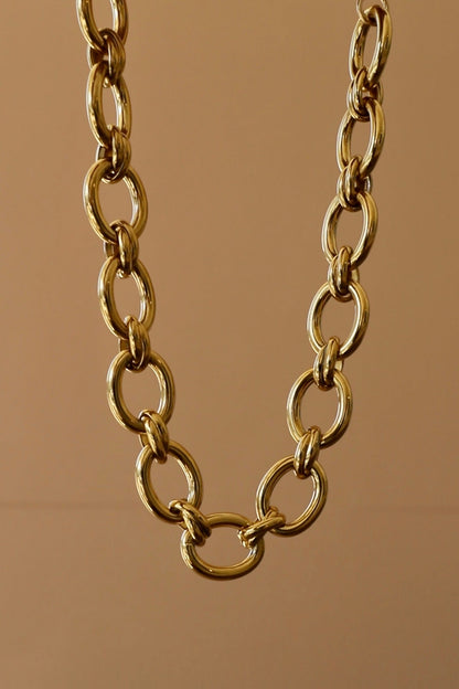 Gold chain necklace on a brown background
