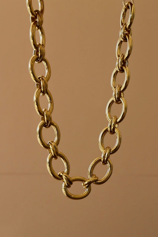 Gold chain necklace on a brown background