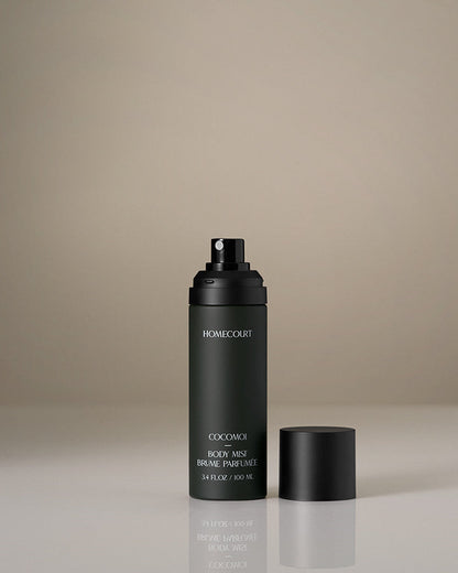 Black perfume bottle with cap on a beige background