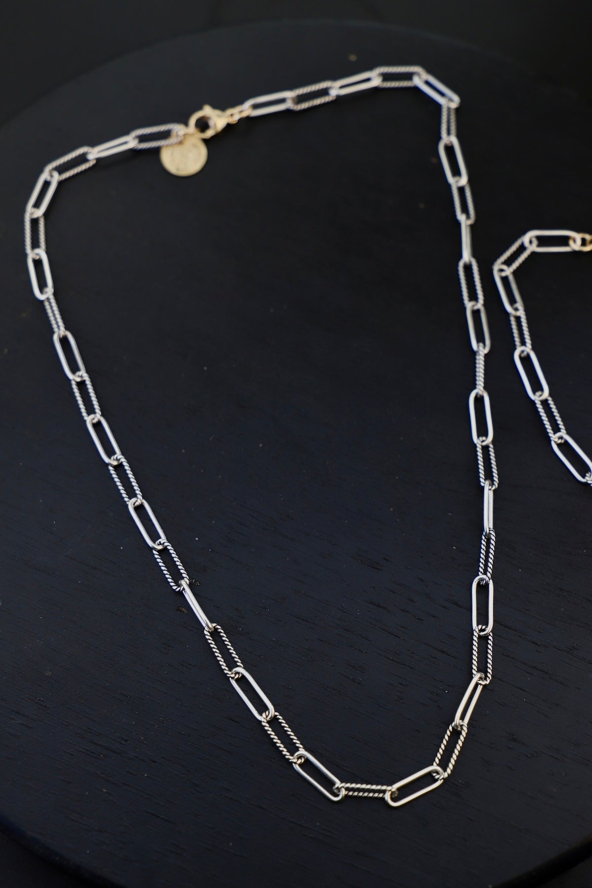 Silver chain necklace on a black background