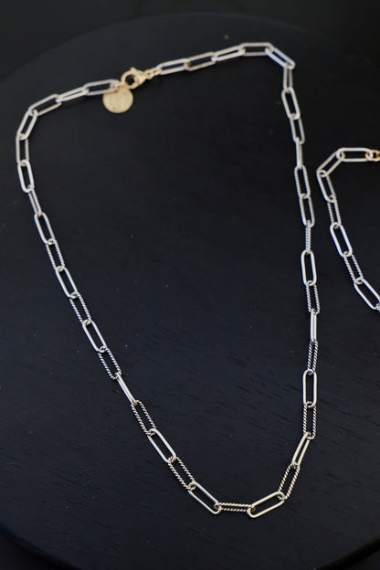 Silver chain necklace on a black background
