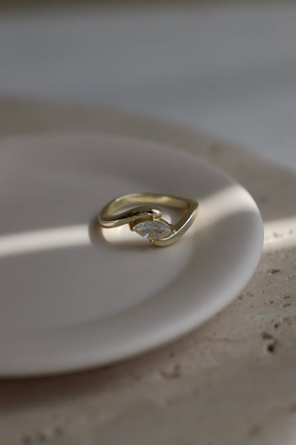 Gold ring with a diamond on a white plate