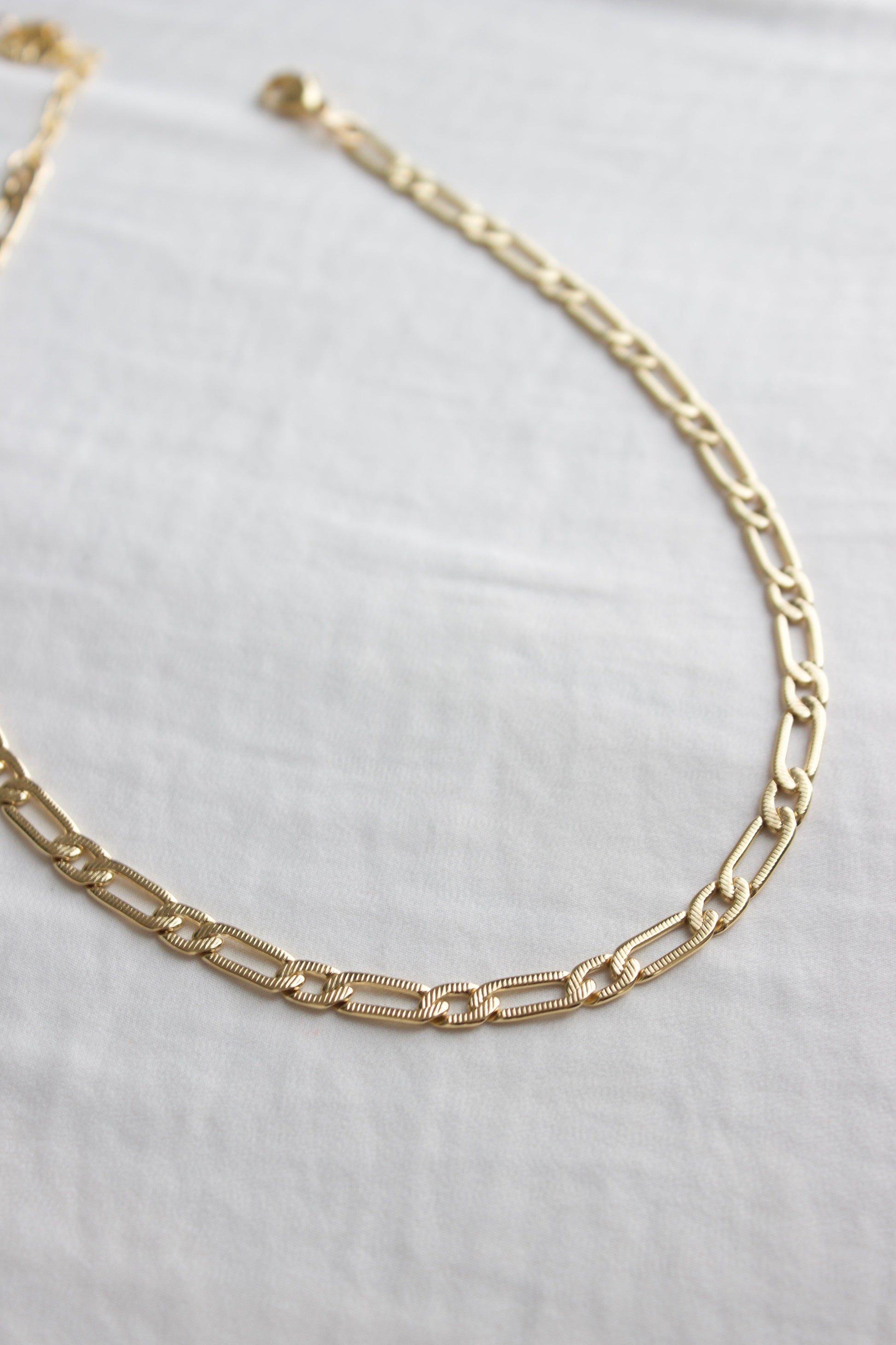 Gold chain necklace on a white background