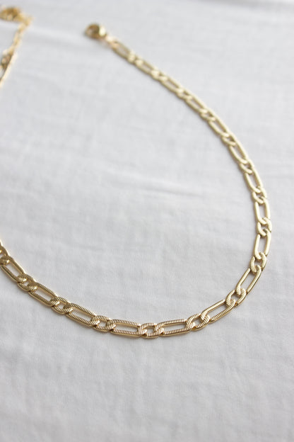 Gold chain necklace on a white background