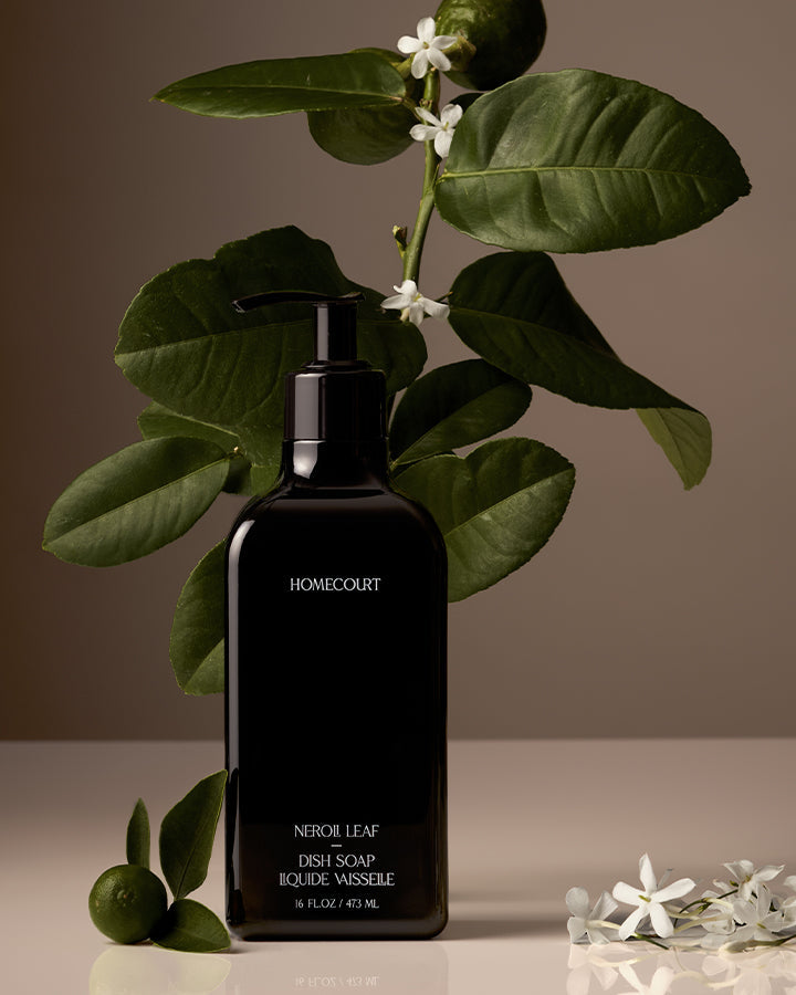 Black soap bottle labeled 'Homecourt' with green leaves and white flowers on a neutral background