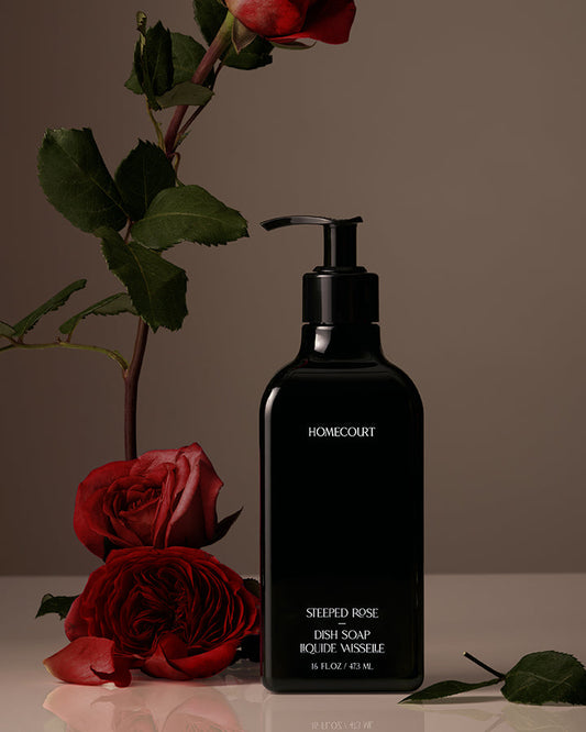 Black bottle labeled 'Homecourt' with red roses on a neutral background