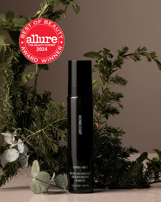 Black deodorant bottle with 'Allure Best of Beauty Award 2024' badge on a neutral background with greenery.