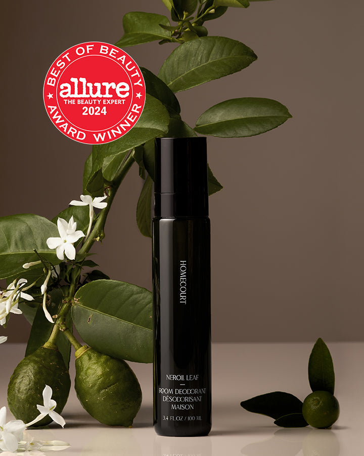 Black room deodorant bottle with green leaves and white flowers on a brown background, featuring the Allure Best of Beauty Award 2024 badge.
