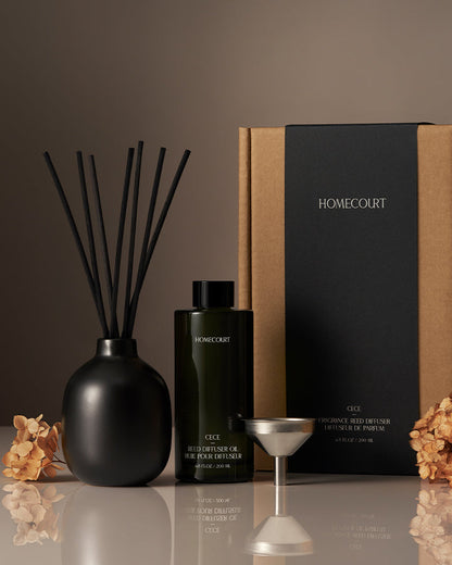 Homecourt diffuser set with black vase, bottle, and packaging on a reflective surface.